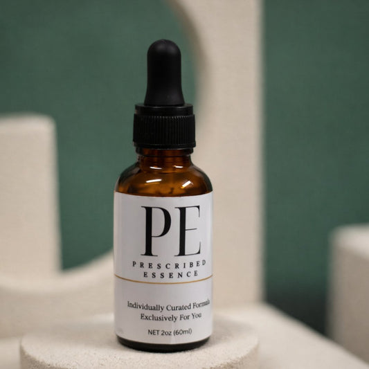 Amber Prescribed Essence bottle on a plinth against a green wall